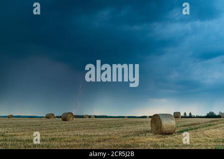 Temporale con fulmine su un campo stoppia in Turingia, Germania. Foto Stock