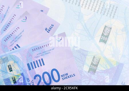 200 le nuove banconote israeliane in shekel sono sovrapposte sullo sfondo di una grande banconota semitrasparente. Background aziendale astratto con spazio di copia Foto Stock