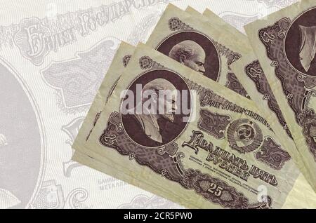 25 rubli russi si trovano in pila sullo sfondo di una grande banconota semitrasparente. Presentazione astratta della moneta nazionale. Concetto aziendale Foto Stock