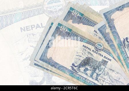 50 le rupie nepalesi si trovano in pila sullo sfondo di una grande banconota semitrasparente. Presentazione astratta della moneta nazionale. Concetto aziendale Foto Stock