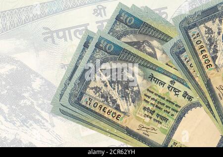 50 le rupie nepalesi si trovano in pila sullo sfondo di una grande banconota semitrasparente. Presentazione astratta della moneta nazionale. Concetto aziendale Foto Stock