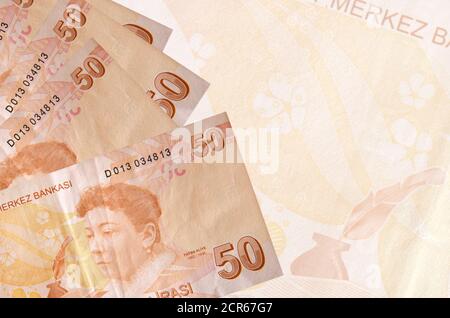 50 lire turche si accatastano sullo sfondo di una grande banconota semitrasparente. Background aziendale astratto con spazio di copia Foto Stock