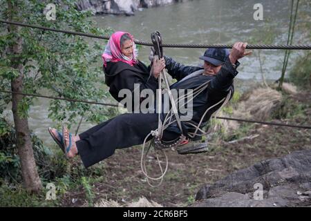 Donna anziana e uomo al punto di approdo della funivia, sul fiume Nujiang, Yunnan Cina 2 aprile 2009 Foto Stock