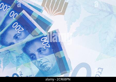 200 le nuove banconote israeliane in shekel sono sovrapposte sullo sfondo di una grande banconota semitrasparente. Background aziendale astratto con spazio di copia Foto Stock