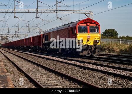 Una locomotiva DB Schenker classe 66 66078 che passa attraverso Chelford, Cheshire con il treno di pietra Dowlow a Theale. Foto Stock