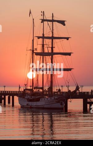 Germania, Meclemburgo-Pomerania occidentale, Ostseebad Binz, molo, nave a vela Loth Loriën, alba Foto Stock