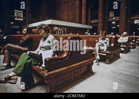I passeggeri seduti sul massiccio panche di legno che si accoppiano con l'architettura del Chicago cavernoso Union Station, Giugno 1974 Foto Stock