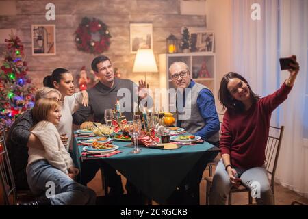 Allegra nipote che prende un selfie con la sua famiglia alla celebrazione di natale. Foto Stock