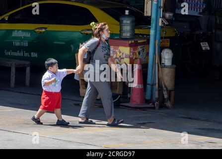 SAMUT PRAKAN, THAILANDIA, 23 2020 LUGLIO, UNA donna conduce un ragazzino. Una madre cammina con suo figlio in città. Foto Stock