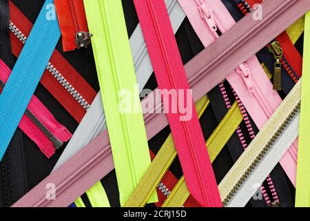 Zip fondo texture di zipper slider. Un sacco di zip in diversi colori. Abiti da cucire, atelier, tessuto e negozio di accessori. Hobby fai da te conce Foto Stock