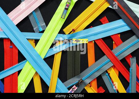 Zip fondo texture di zipper slider. Un sacco di zip in diversi colori. Abiti da cucire, atelier, tessuto e negozio di accessori. Hobby fai da te conce Foto Stock