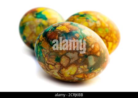 Tradizioni. Uova di pasqua di colore giallo verde fatte a mano dipinte in marmo su sfondo bianco Foto Stock