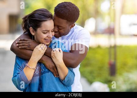 Affettuosa coppia multietnica che abbraccia l'ambiente esterno Foto Stock