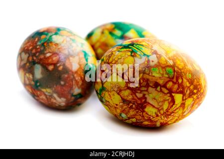 Tradizioni. Uova di pasqua di colore giallo verde fatte a mano dipinte in marmo su sfondo bianco Foto Stock