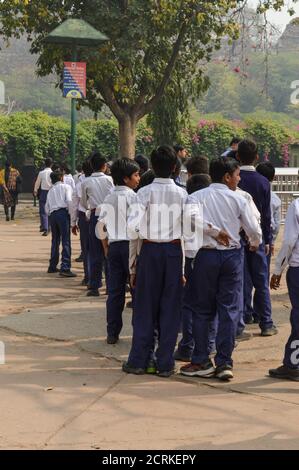 Un gruppo di bambini che visiteranno il parco zoologico nazionale in coda fuori dallo zoo di Delhi. Foto Stock