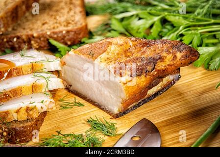 la carne affumicata si trova sulla tavola con erbe e salsa Foto Stock