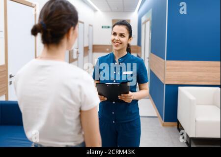 Il chirurgo femminile parla con il paziente nella sala clinica Foto Stock