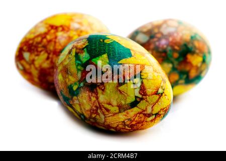 Tradizioni. Uova di pasqua di colore giallo verde fatte a mano dipinte in marmo su sfondo bianco Foto Stock