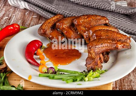 Composizione con ali di pollo affumicate sul tavolo Foto Stock