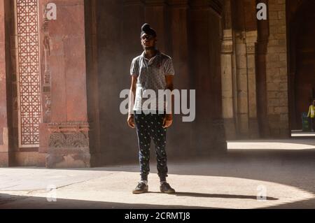 Un ragazzo indiano che dà la posa per sparare di moda all'interno del vecchio forte. Foto Stock