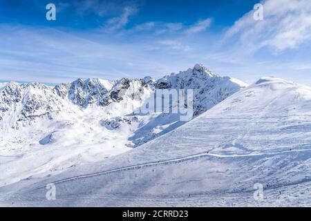 Persone sciare e snowboard da Kasprowy Wierch, vacanze invernali. Incredibile catena montuosa con cime innevate dei Monti Tatra Polonia Foto Stock