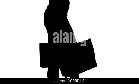 Silhouette donna giovane con borse per lo shopping a piedi fuori dal negozio. Foto Stock