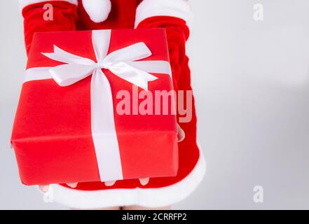 Closeup mano donna tenendo presente scatola in xmas giorno con sorpresa isolato su sfondo bianco, braccio ragazza felice dare scatola regalo rosso con carta da imballaggio e wh Foto Stock