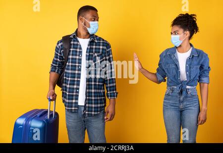 African Woman gesturing Stop al Tourist Standing su sfondo giallo Foto Stock