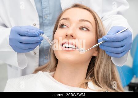 Donna che ha denti esaminati presso dentisti. Sbiancamento dei denti, concetto di cura dentale Foto Stock