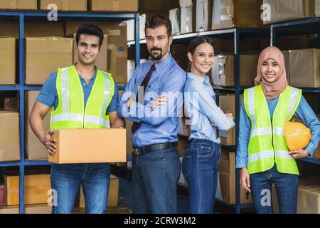 Ritratto del gruppo di lavoratori magazzino Diversity in piedi e orgoglioso del team per la visione e target in magazzino locale, musulmano, indiano, bianco caucasi Foto Stock