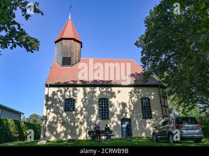 Illmersdorf, Germania. 17 Settembre 2020. Il sole di mezzogiorno risplende attraverso i rami di vecchie querce sulla piccola chiesa del villaggio. La piccola chiesa a graticcio di Illmersdorf conserva un tesoro speciale: Nella cripta sono conservate undici mummie. Chi erano durante la loro vita è ora conosciuto. E' contestato che alcuni di essi possono essere visti a causa di coperchi di vetro per bara. Credit: Patrick Pleul/dpa-Zentralbild/ZB/dpa/Alamy Live News Foto Stock