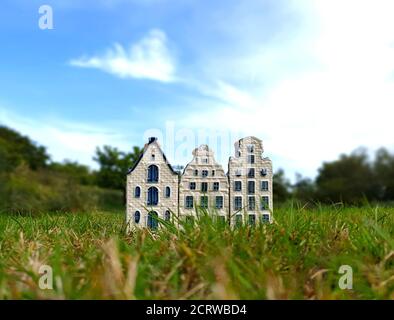 Primo piano di tre case di canale blu olandese Delftware in porcellana e dipinto a mano all'esterno sull'erba, prodotto tipico olandese di esportazione, selettivo f Foto Stock