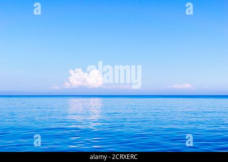 Orizzonte sul Mar Egeo con una nuvola bianca in lontananza, Isola di Karpathos, Grecia Foto Stock