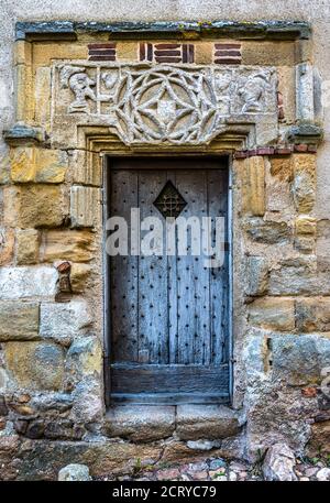 Porta medievale e testata in pietra scolpita a Saint-Benoit-du-Sault, Indre (36), Francia. Foto Stock