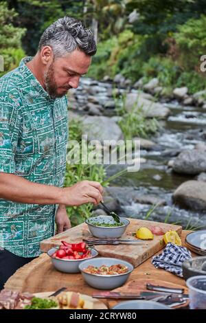 Lo chef prepara Chimichurri da Scratch al Camping picnic barbecue Foto Stock