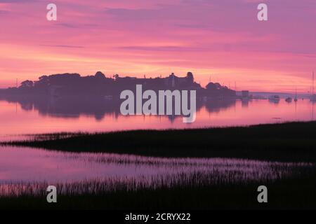 La luce Dawn illumina un rosa vibrante sopra la piscina di Biddeford sulla costa del Maine. Foto Stock