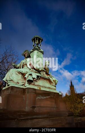 Glasgow / Scozia - 13 novembre 2013: Caduta in città. Statua in bronzo verde sul ponte Kelvin Way. Torre dell'Università di Glasgow sullo sfondo. Alberi gialli Foto Stock