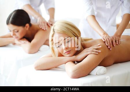 Graziose amiche che si massaggiano insieme nel centro benessere Foto Stock