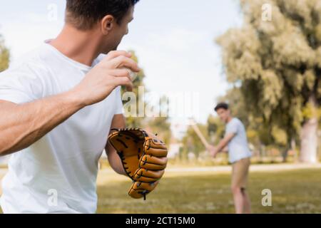 fuoco selettivo dell'uomo in guanto di pelle che gioca il baseball con figlio adolescente nel parco Foto Stock