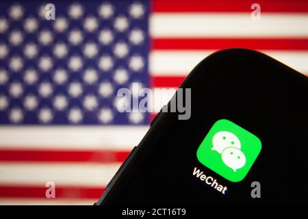 Cellulare con icona WeChat davanti alla bandiera d'America. il presidente degli Stati Uniti Donald Trump vieta le applicazioni della Cina a causa della sicurezza nazionale Foto Stock