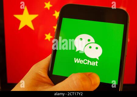 Cellulare con logo WeChat davanti alla bandiera della Cina. il presidente degli Stati Uniti Donald Trump vieta le applicazioni della Cina a causa della minaccia per la sicurezza nazionale. Foto Stock