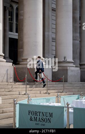 Un cameriere si occupa dei gradini della Royal Exchange dove Fortnum & Mason hanno allestito un ristorante e bar all'aperto di fronte alla Bank of England nella City di Londra, durante la pandemia di Coronavirus, il 9 settembre 2020, a Londra, Inghilterra. Il 16 settembre 2020, a Londra, Inghilterra. Foto Stock