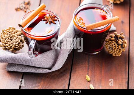 VIN brulé e miele su sfondo ligneo. Due tazze di VIN brulé e spezie autunnali. Bevanda calda di Natale in stile rustico Foto Stock