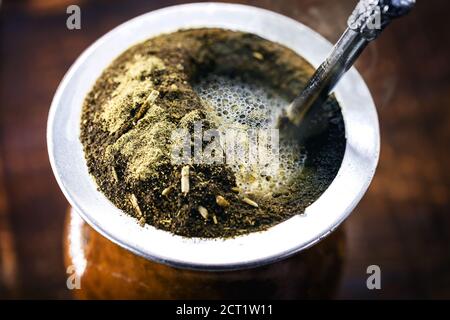 Tè Yerba mate in calabash su tavolo di legno. Bevanda tradizionale argentina, uruguaiana e brasiliana. Bevanda tipica del rio grande do sul Foto Stock