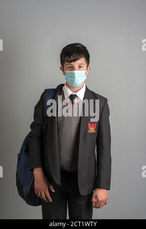 Anno 8 studente britannico in unisfirm scuola e facemask, Regno Unito, Surrey Foto Stock