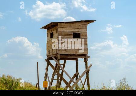 Caccia nascondiglio torre di osservazione costruita da tavole di legno, cielo blu sullo sfondo Foto Stock