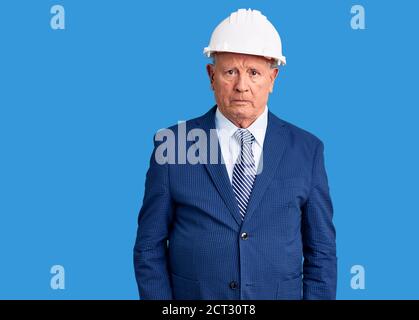 Uomo anziano bello grigio-capelli che indossa vestito e architetto hardhat scettico e nervoso, accigliato sconvolto a causa del problema. Persona negativa. Foto Stock