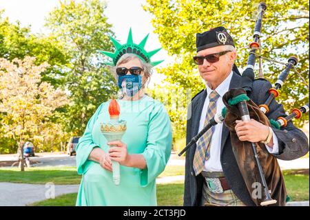 Donna vestita come la Statua della libertà in piedi con un Bagpiper al rally a Concord per onorare la vita Corte Suprema Giustizia Ruth Bader Ginsburg. Foto Stock