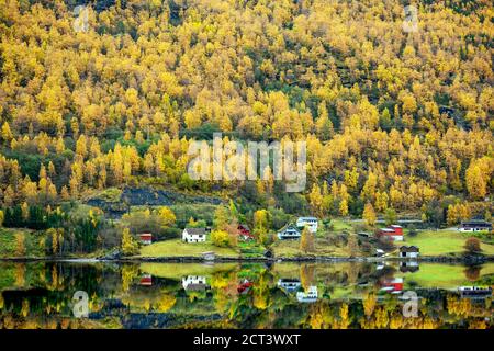 La casa si trova sul lungomare della valle durante la stagione autunnale. Le foglie diventano gialle tutte le montagne che riflettono la splendida acqua del ci Foto Stock