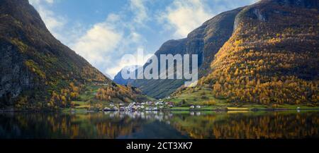 Panoramica il villaggio di Undredal è un piccolo villaggio sul fiordo. Aurlandsfjord la costa occidentale della Norvegia, le alte montagne e i villaggi si riflettono nel wate Foto Stock